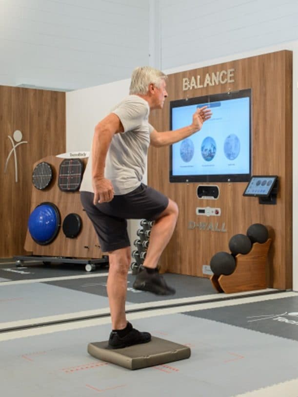Adulto mayor durante el entrenamiento del equilibrio y la coordinación en el D-Wall en Nextherapy